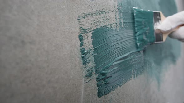 Renovation Painting Walls with Blue Paint Using Brush Closeup