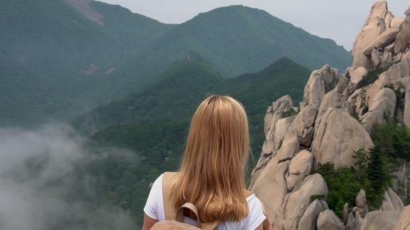 Young Female Blonde Traveler Enjoying Ulsanbawi Rock View. Active Lifestyle and Freedom Concept