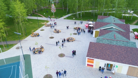 Outdoor Cafe with Guests at Round Tables in Park