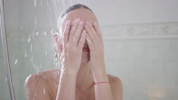 Front View Portrait of Happy Cheerful Young Slim Woman Washing Off Shampoo Smiling