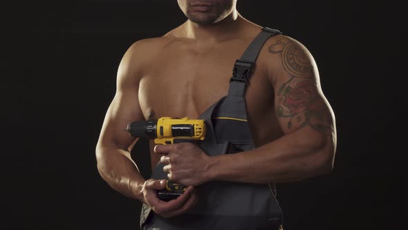 Cropped Shot of a Musuclar Sexy Shirtless Ripped Repairman Holding a Drill