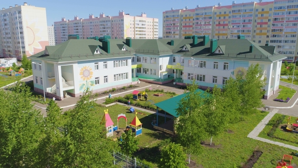 Modern Kindergarten with Playgrounds Among Lawns
