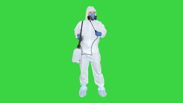 Man Wearing an NBC Personal Protective Equipment (Ppe) Suit Spraying Disinfectant Water To Remove