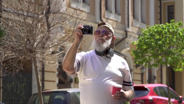 Stylish Senior Man Hold a Cup with Coffee Take a Photo in the Summer City