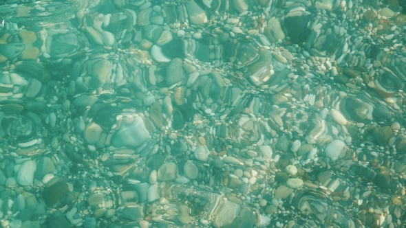 Through the Crystal Clear Sea Water You Can See a Variety of Sea Stones on the Sea Coast