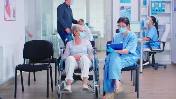 Nurse Taking Notes From Disabled Senier Patient