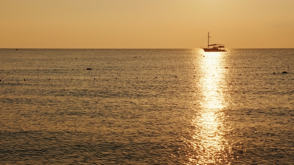 Fishing Boat in the Sea. At Sunrise, a Beautiful Silhouette in a Shiny Path on the Water