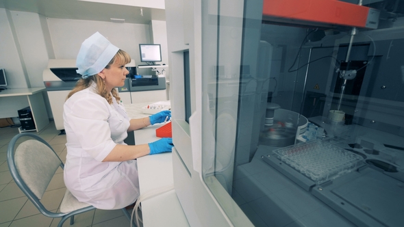 Blood Testing Equipment Performs Tests, While a Nurse Works with the Computer alt