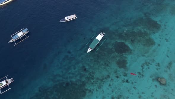 Aerial view at group of traditional boats anchored next Gili Trawangan island.