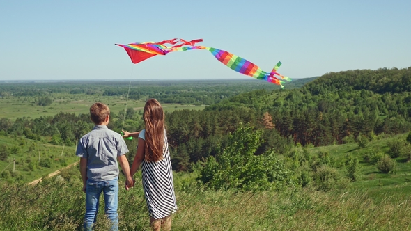 Little Boy and Girl Holding a Flying Kite