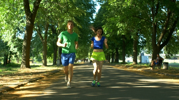 Athletic Attractive Couple Running in Public Park
