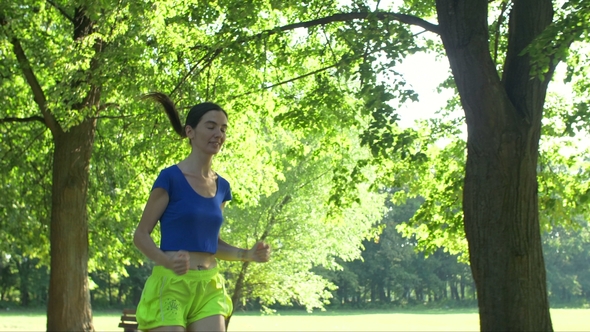 Smiling Female Runner Running in Summer Park