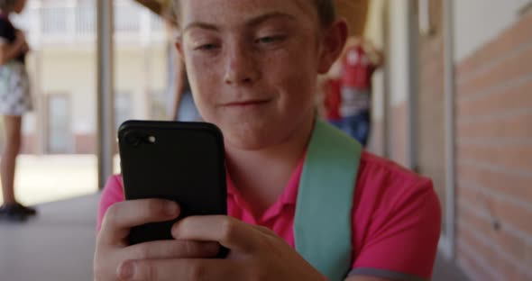 Girl using smartphone in the school corridor