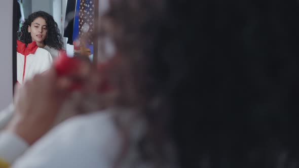 Woman Looking at Herself in the Mirror in Store