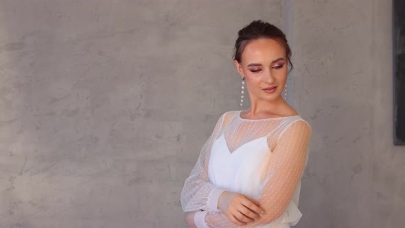 A Girl in a White Dress Poses Elegantly for a Photographer