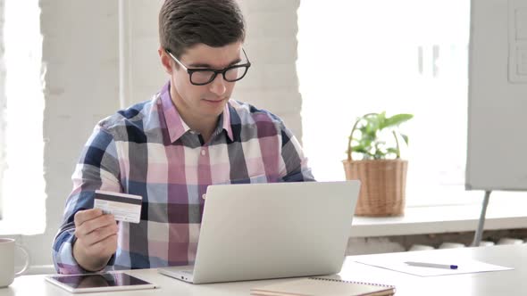 Successful Online Shopping by Young Man on Laptop