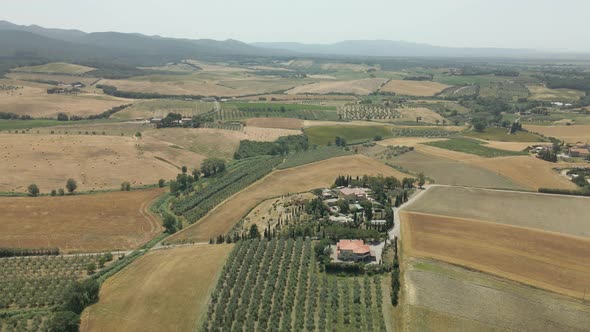 Aerial images of Tuscany in Italy cultivated fields summer, Flight over an agricultural farm with ne