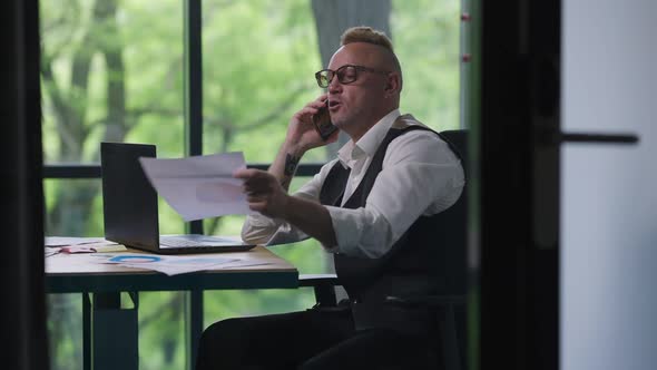 Stressed Disappointed Caucasian Man Arguing on Phone Hanging Up Holding Head in Hands