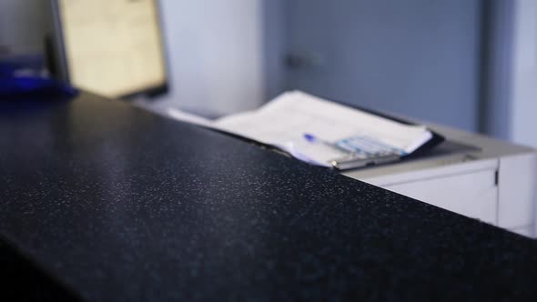 View of Woman's Hand Puts Key Chain in Desk and Other Woman's Hand Takes It