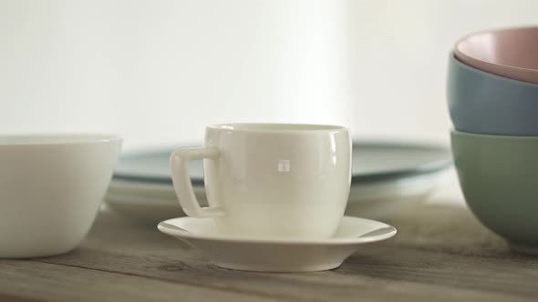 A Large Set Of Clean Dishes. A Stack Of White And Gray Plates And A Coffee Cup And Saucer. 