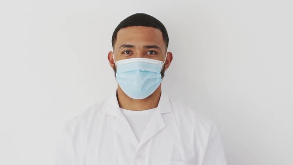 Male heath worker wearing face mask against white background