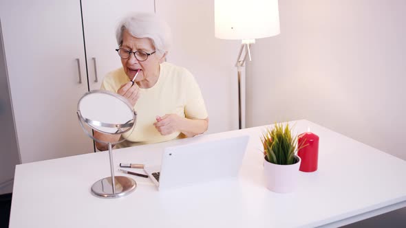 Elderly Woman Applying Make Up in the Office