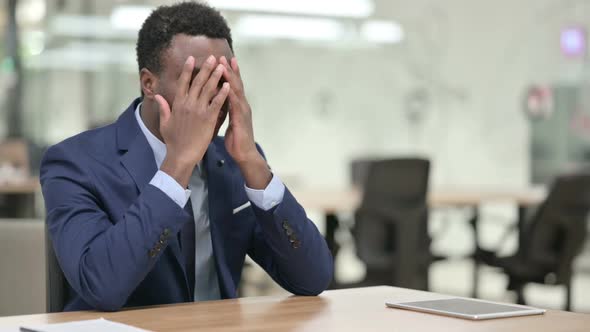 Upset African Businessman Worried While Sitting in Modern Office