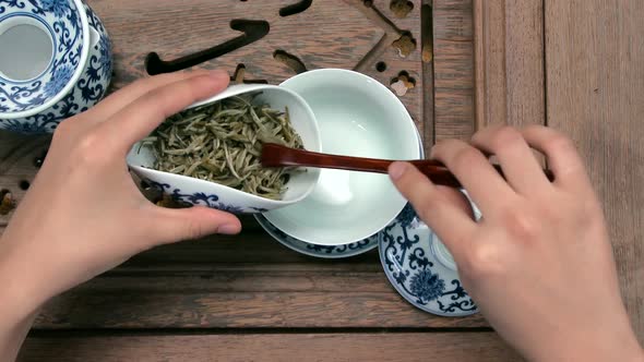 Filling A Brown Teapot Through A Funnel