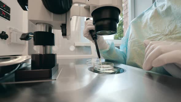 Person Works with Microscope in Laboratory. alt