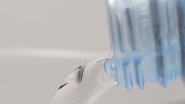 Macro shot of pouring of clear water from a plastic bottle