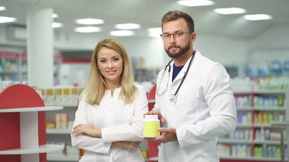 Two Beautiful Pharmacist in Uniform Recommends the Drug for Treatment.