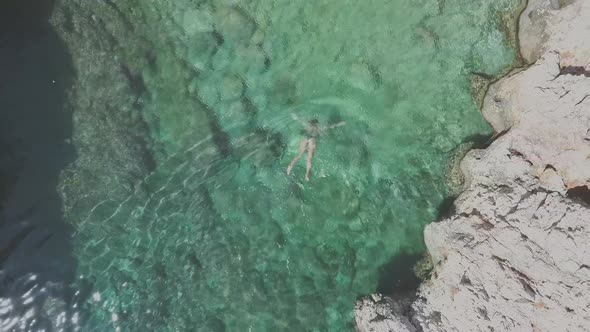 Woman dives into water. Aerial view of Katholiko Gorge in Crete. Relax concept