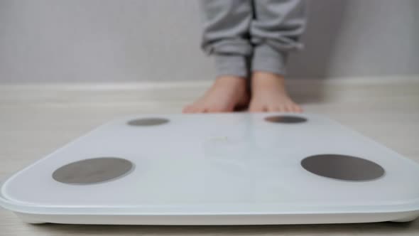 Woman Stands on Electronic Scale to Measure Weight Closeup