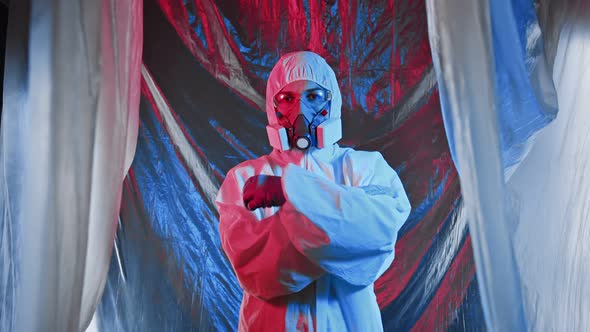 A Woman in Chemical Protection Glasses and a Medical Mask Confidently Folds Her Hands on Her Stomach