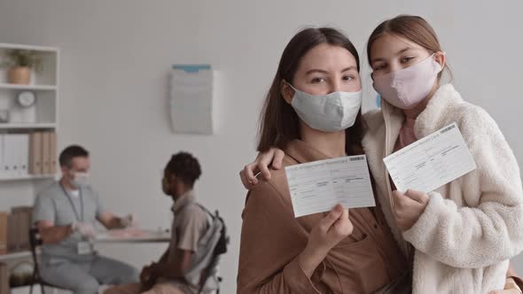 Mother and Daughter Showing Vaccination Cards