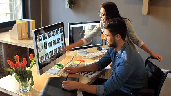Male and female graphic designer working on computer
