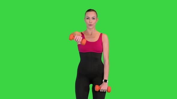 Woman Lifting Dumbbells Working on Her Shoulders on a Green Screen Chroma Key