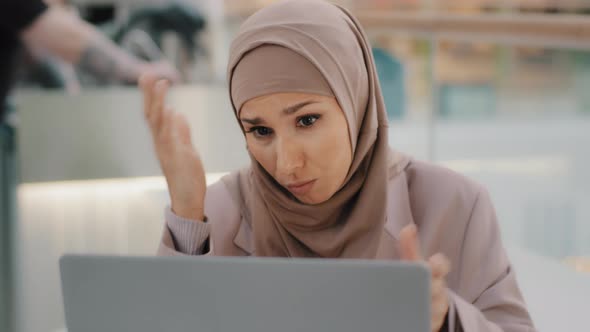 Young Arab Sorrowful Woman in Hijab Reading Message on Laptop Gets Bad News Denied Bank Loan Job