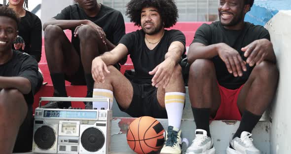 Group of young multiracial people listening music from vintage boombox stereo in the city