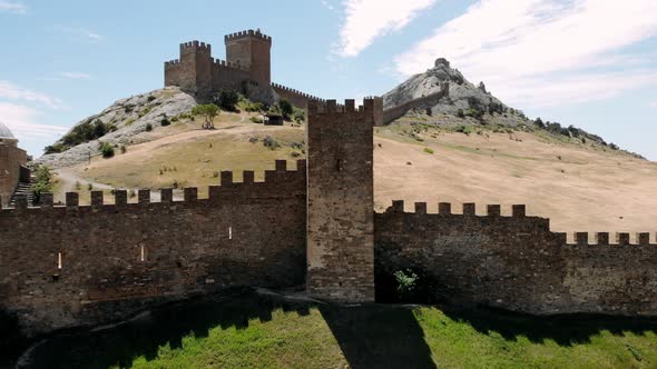 Ancient Medieval Genoese Fortress Tower on Mountain Range Rocks Above Sea Aerial View From Drone to