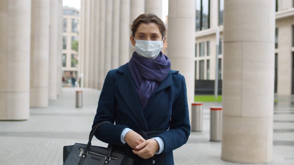 Portrait of Businesswoman Standing in Street Wearing Face Mask and Looking at Camera