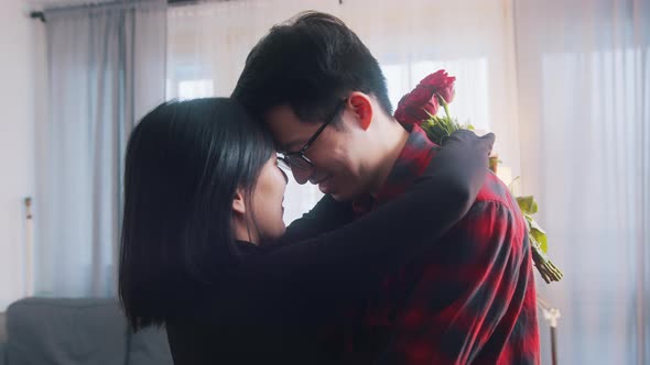 Young Asian Man Giving Red Roses to His Girlfriend