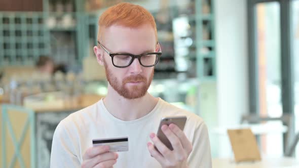 Portrait of Online Payment on Smartphone By Redhead Man