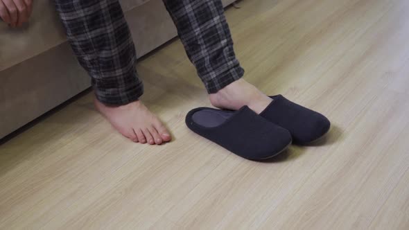 A Man in Pajamas is Wearing House Slippers on His Feet