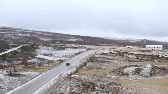 Winter Road Trip Driving In The Nature Alongside Trees and Snow In Dovre, Norway - aerial drone shot