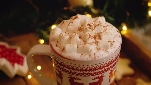 Close-up slider shot of a mug with hot coffee with marshmallows