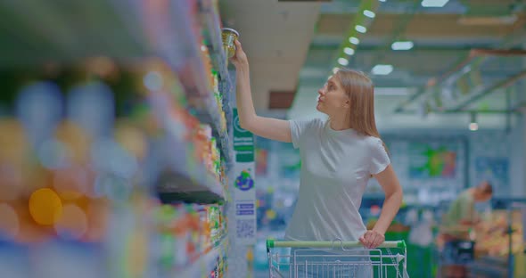 Beautiful Woman Walks Through a Grocery Store and Selects Products Grocery Department