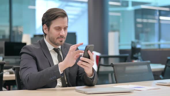 Successful Businessman Celebrating on Smartphone