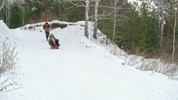 Men Sledding in Park