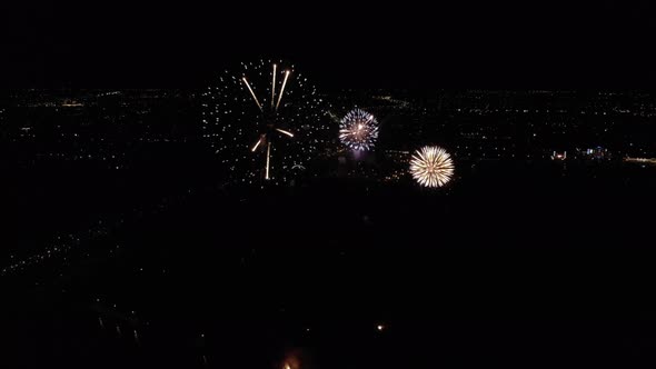 Drone Video of Golden Firework Blowing Up High in the Sky Over City at Night